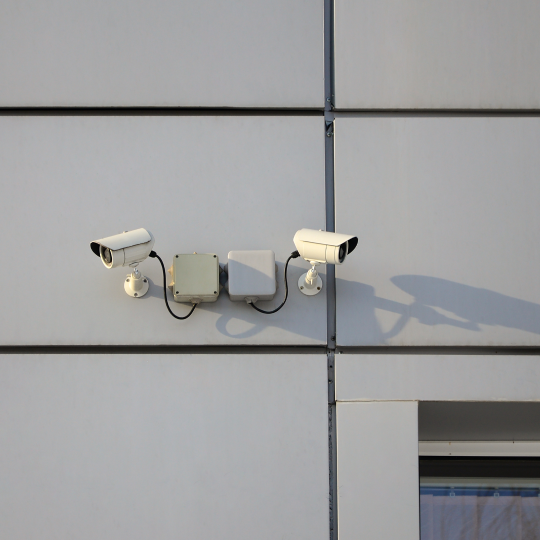 white-surveillance-camera-built-into-metal-wall-office-buildin